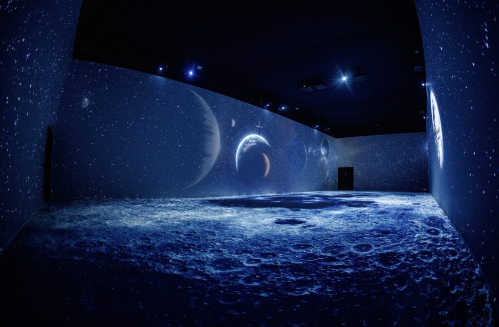 Guests standing inside a fully projected room at Plein Publiek BXL